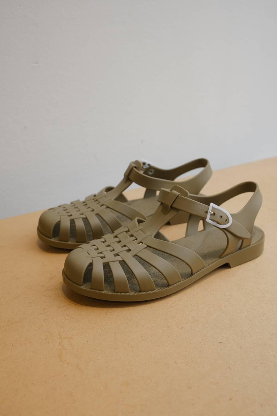 französische klassische Badesandalen sind Riemensandalen aus Gummi zum Schwimmen und Baden, in der Farbe Schlamm (gün-grau), geflochtener Look, weiße Schnalle